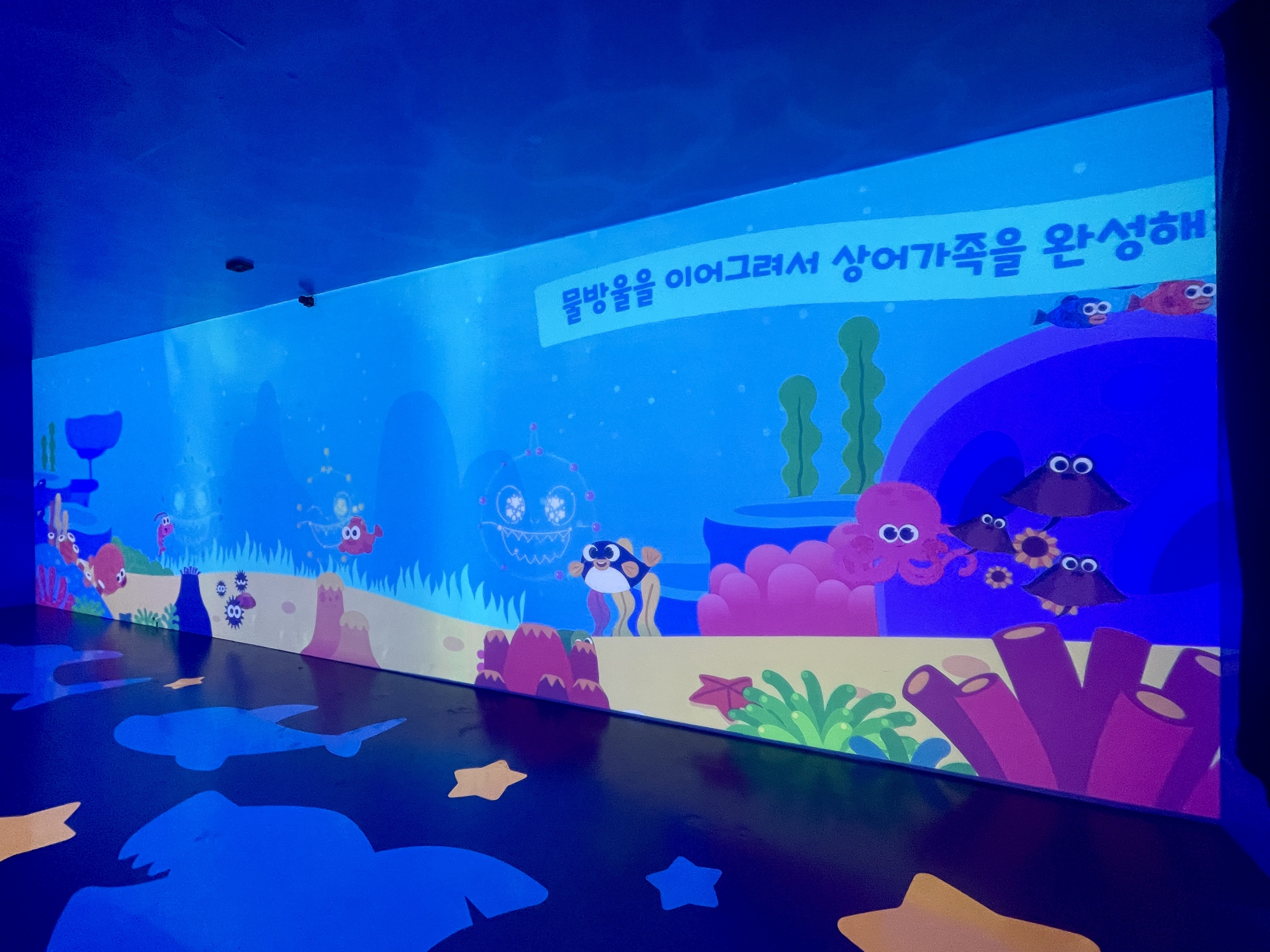 8m 인터랙티브 월 전체 모습. 바다 생물들이 헤엄치고, 말미잘의 거품을 이어 그리면 아기상어가 완성된다.